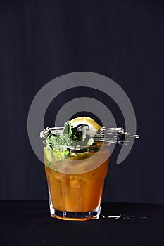 Exotic alcoholic drink with fruits on black background. drink a shot of absinthe, tequila and vodka with lemon in the glass cup on