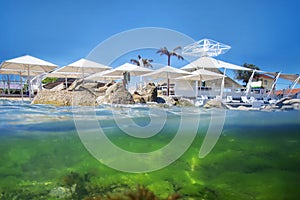 Exotic beach, half under water on the background of the uncovered sun umbrellas