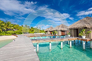 Exotic beach with water bungalows at Maldives, wooden bridge into paradise island