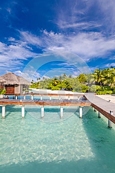 Exotic beach with water bungalows at Maldives, wooden bridge into paradise island