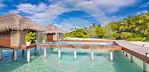 Exotic beach with water bungalows at Maldives, wooden bridge into paradise island