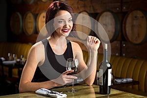 Exotic beautiful woman on a dinner date at winery barrels enjoying evening night out