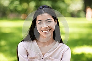 Exotic Beauty. Portrait Of Smiling Asian Girl Posing Outdoors In Green Park