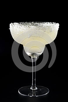 Exotic cocktails and mexican culture concept theme with a glass of margarita cocktail with salt on the brim isolated on dark black