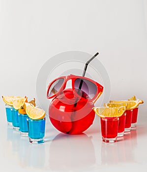 Exotic drink in a ball-shaped glass, eight drinks in a shotglass, sunglasses