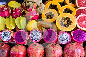 Exotic summer fruits laid out in shopping mall or market. Dragon fruit, pineapple, persimmon, mango, annona cherimola
