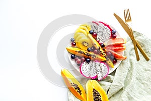 Exotic fruit dish with dragon fruit and papaya, top view