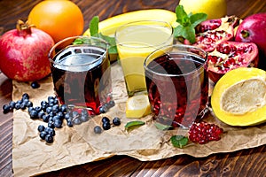 Exotic fruit juice, choke berry juice, aronia juice, pomegranate juice, banana smoothie and organic fruits on table