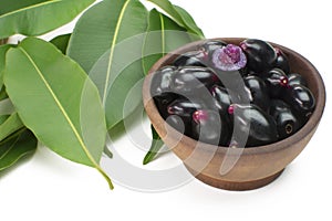 Exotic fruit Syzygium cumini called in Brazil as jamelÃ£o in wood bowl background with one cut