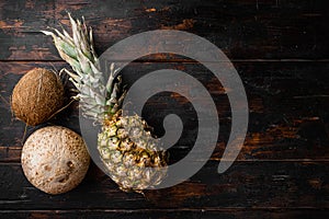 Exotic fruits, pineapple and Coconut, on old dark  wooden table background, top view flat lay, with copy space for text