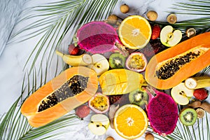 Exotic fruits and tropical leaves on table