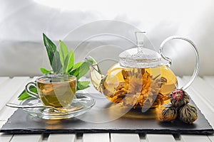 Exotic green tea with flowers in glass teapot