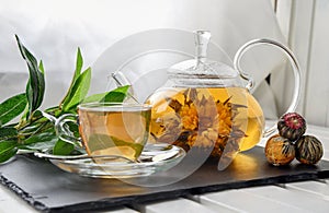 Exotic green tea with flowers in glass teapot