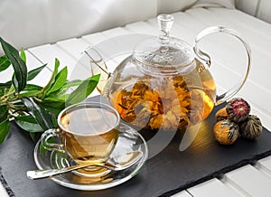 Exotic green tea with flowers in glass teapot