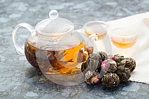 Exotic green tea with flowers in glass teapot