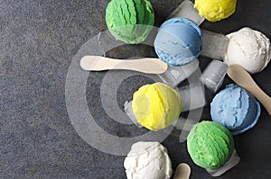 Exotic kinds of ice cream with ice cubes on gray table,top view.Unusual types of ice cream balls Closeup of various ice cream flav