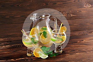 Exotic lemonade with mint and oranges. Big party glasses on a table background. Fresh cocktails at the bar. Copy space.