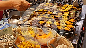 Exotic Oriental Asian sweet delicious desserts, unusual colorful traditional dishes on the counters of a bazar with street food.