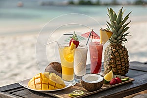 Exotic summer drinks with sandy beach backdrop