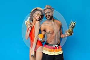 Exotic Summer. Positive black couple posing with fresh tropical fruits