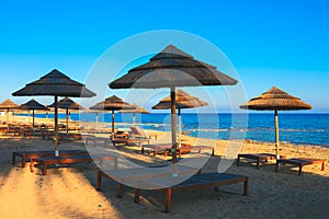 Exotic sunbeds and umbrellas on the beach