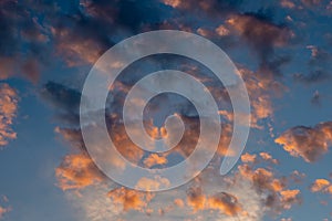 Exotic sunrise cloudscape sky with pink black and white coloured cumulus cloud formation in a pastel blue sky. Sunset or sunrise