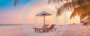 Exotic sunset summer island landscape love couple chairs umbrella palm leaves shore, coast. Romantic travel destination