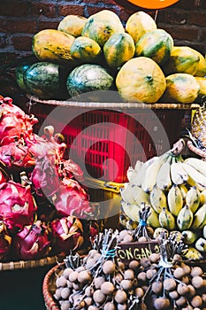 Exotic and tropical fruits on the market of Thailand, Vietnam. Mini bananas, longan, pitaya Dragon Fruit, papaya