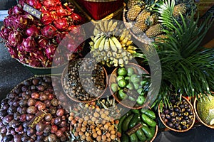 Exotic and tropical fruits on the market of Asia, Thailand, Vietnam. Mini bananas, longan, pitaya, papaya