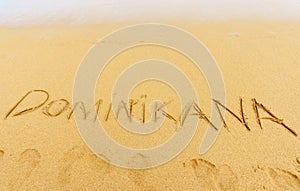 Exotic vacation. Dominikana country written on the sand photo