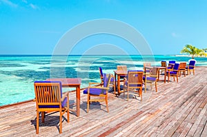 An exotic view of a wooden restaurant on stilts on a background of azure water and sunny sky