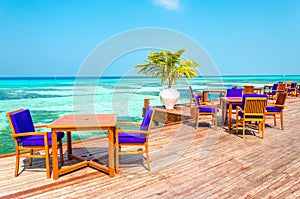 An exotic view of a wooden restaurant on stilts on a background of azure water and sunny sky