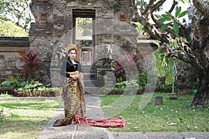 Exotic woman wearing Balinese kebaya and Endek woven fabric