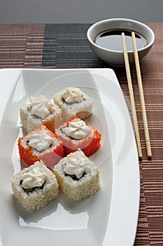 Exotically japanese seafood, roll are lying on a white plate.