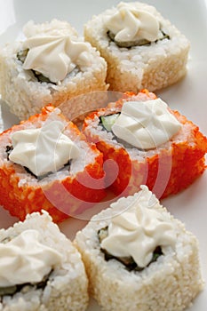 Exotically japanese seafood, roll are lying on a white plate. Close up.