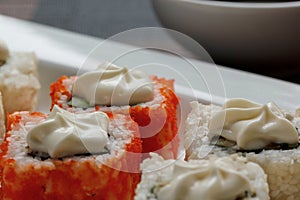 Exotically japanese seafood, roll are lying on a white plate. Close up.