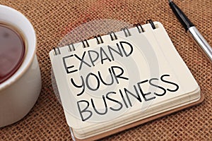 Expand your business, text words typography written on book against wooden background, life and business motivational