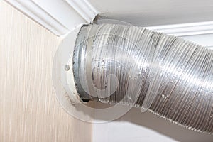 Expandable metallic aluminium corrugated air-conditioning ventilation pipe in kitchen connecting a cooker hood and a ventilation