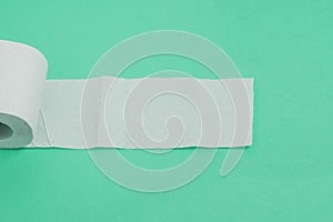 Expanded roll of toilet paper. Empty white sheet on aqua menthe background. A concept for treating diarrhea, incontinence and