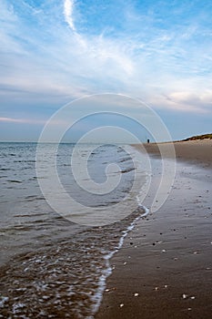 Expansive Beach View with Distant Figure Under a Wide Sky