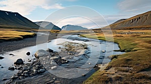 Expansive Landscape: A Stream Flowing Through A Mountain Field