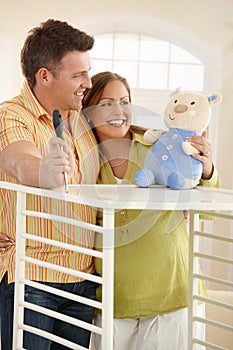 Expectant couple smiling at toy photo