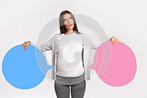 Expectant Girl Holding Blue And Pink Speech Bubbles Near Belly