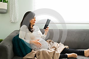 Expectant mother enjoying a digital book about pregnancy