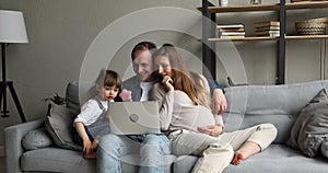 Expectant mother father toddler girl do shopping online on laptop