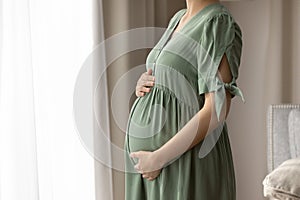 Expectant mother wearing dress for pregnant, holding big baby bump