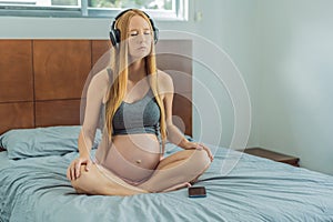 Expectant woman finds serenity in pregnancy, listening to affirmations and meditating for calmness