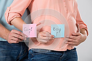 Expecting Couple Holding Paper With Girl And Boy Text