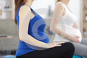 expecting lady trainer giving yoga for pregnant women