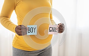 Expecting woman holding color cards for baby boy or girl